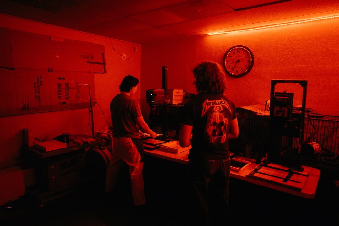 man typing on computer in a dark room