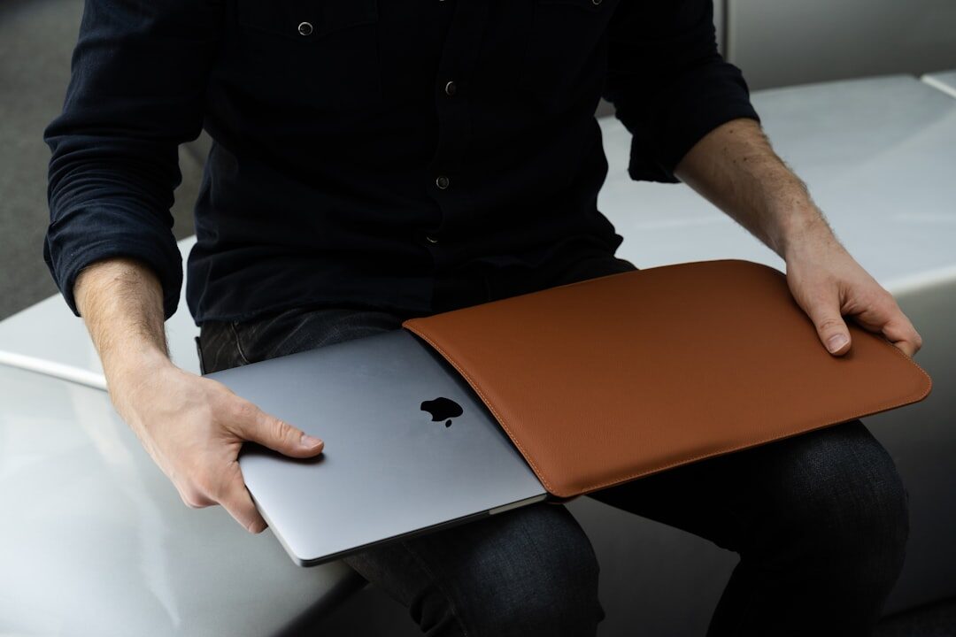 person holding wallet and looking at laptop screen