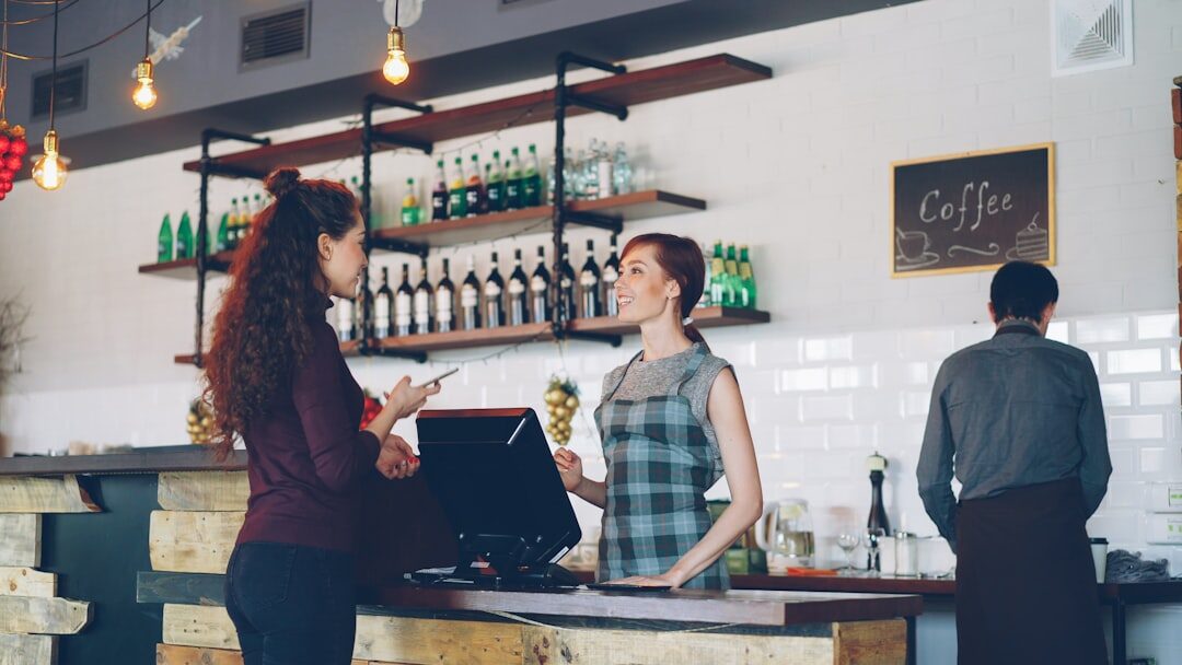 woman coding on macbook in coffee shop