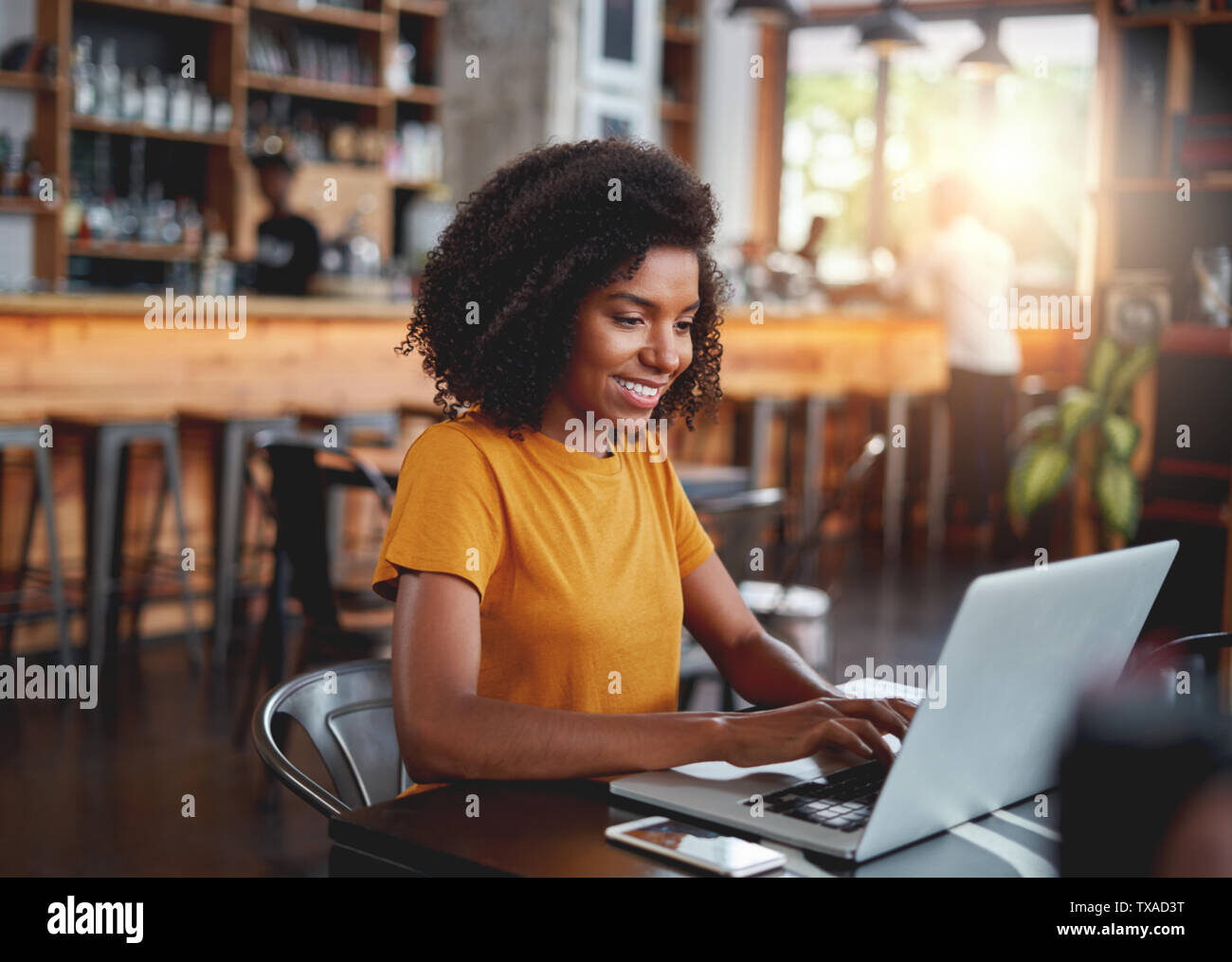 A woman typing on a laptop in a cafe