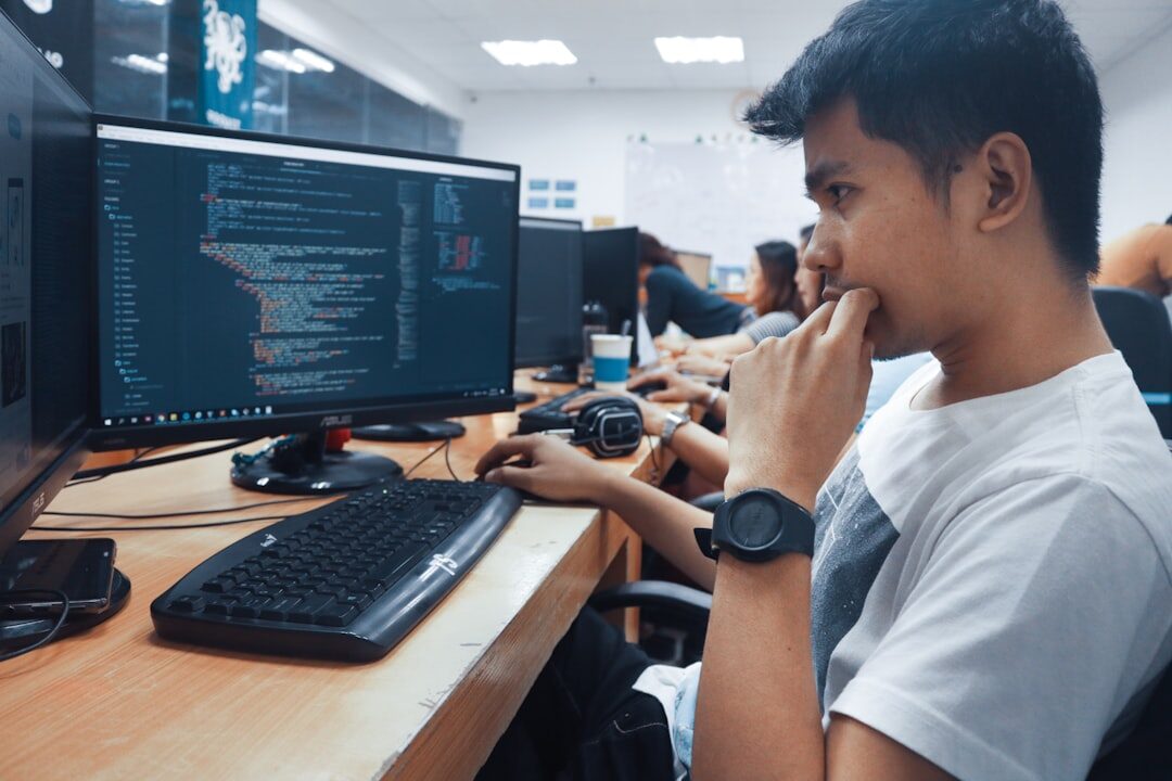 man coding on desktop computer
